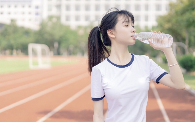 校花美女在操场跑步休息手持矿泉水喝水