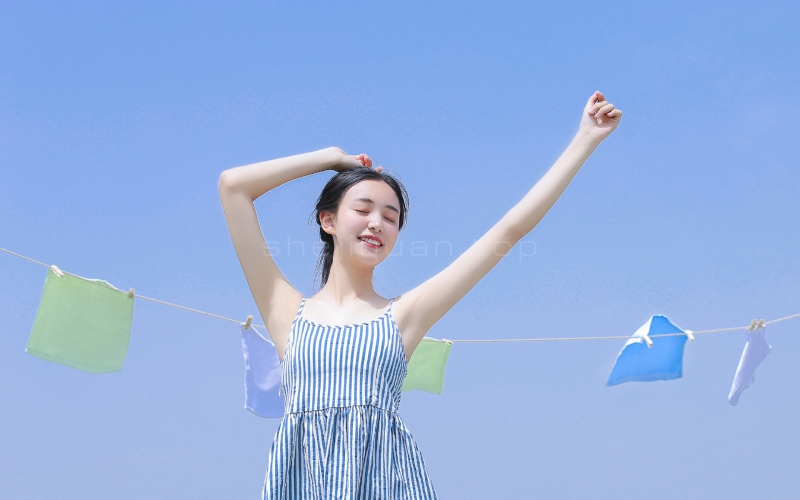 蓝天天一位开朗的小美女在晾衣架下跳舞