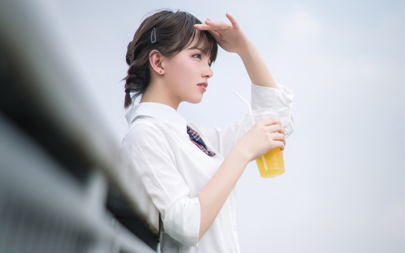 阳光明亮的户外,一个手端柠檬茶的小美女