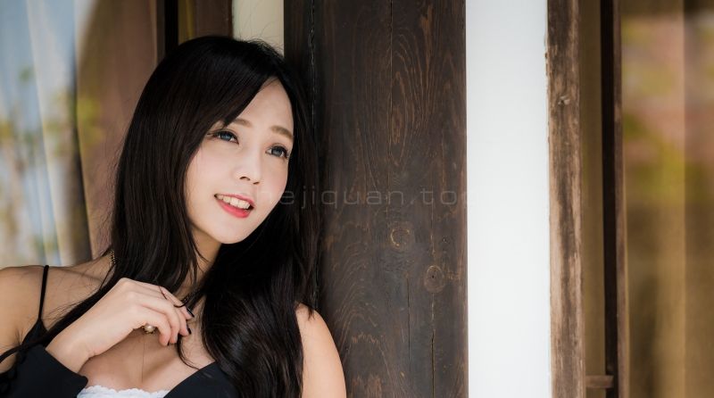 脸庞迷人的美女一头乌黑的长发依靠在门框上身材丰满迷人