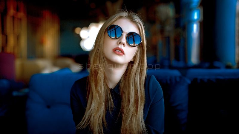 一头大波浪金发散落胸前戴着蓝色太阳镜的美女侧脸看着天空红唇微张脸胖白皙玉颈修长迷人